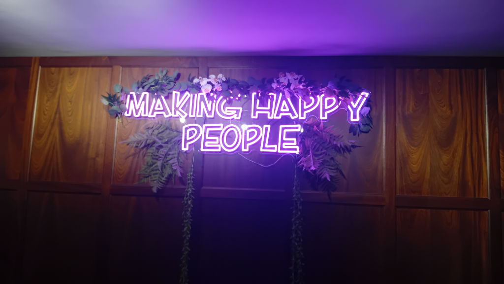 'Making happy people' neon light sign inside the pub